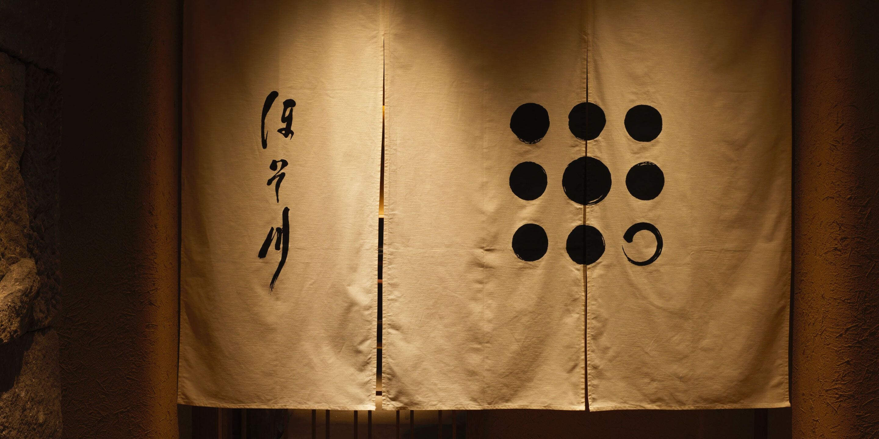 Un paravent japonais traditionnel de type shoji, orné de calligraphie et d’un motif géométrique.