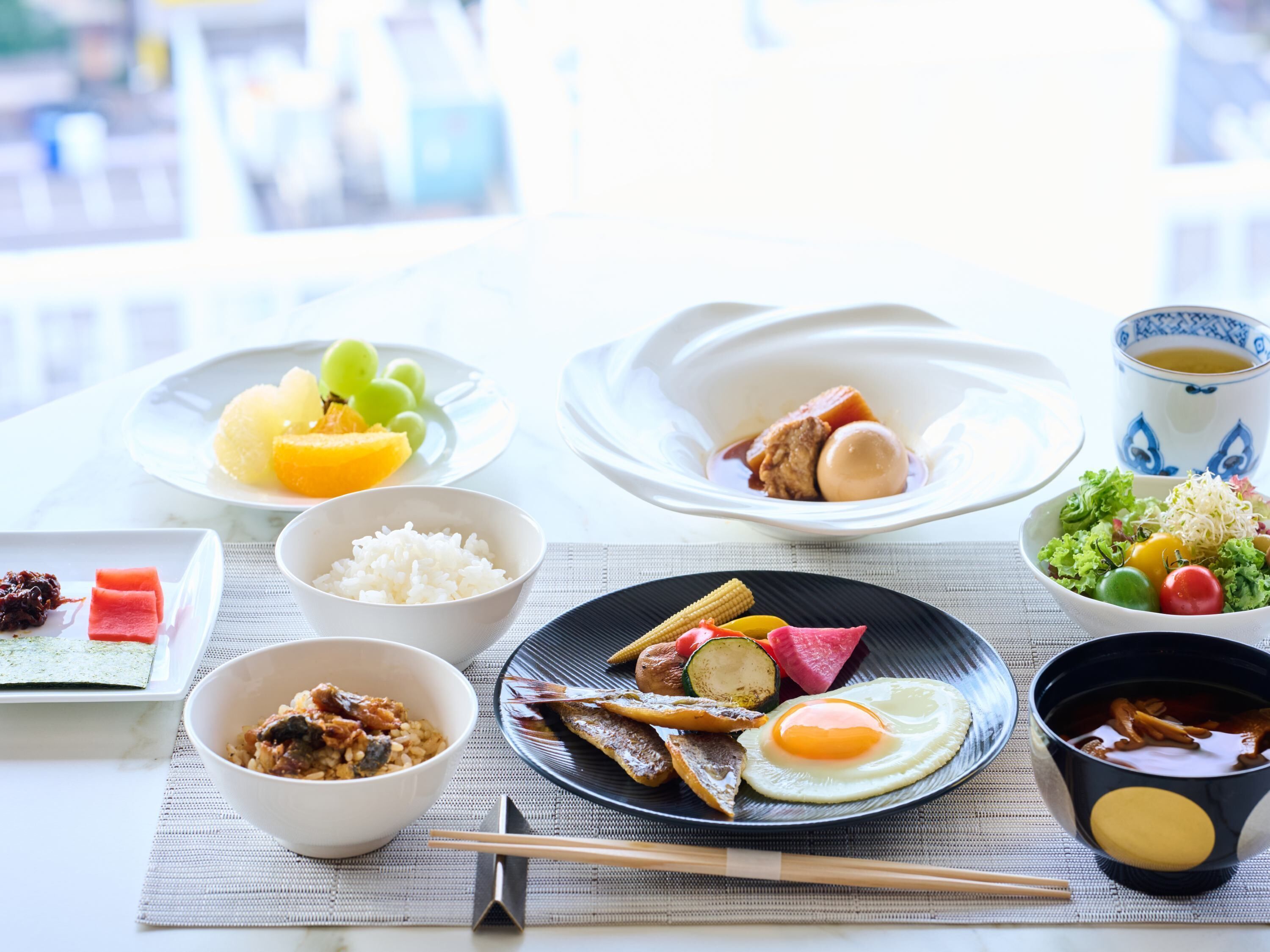 A table with various dishes including rice, eggs, and vegetables, suggesting a meal setting.