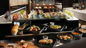A buffet setup with various food items, including meats, cheeses, and salads, arranged on a counter. - Nagoya Kanko Hotel (Nagoya)
