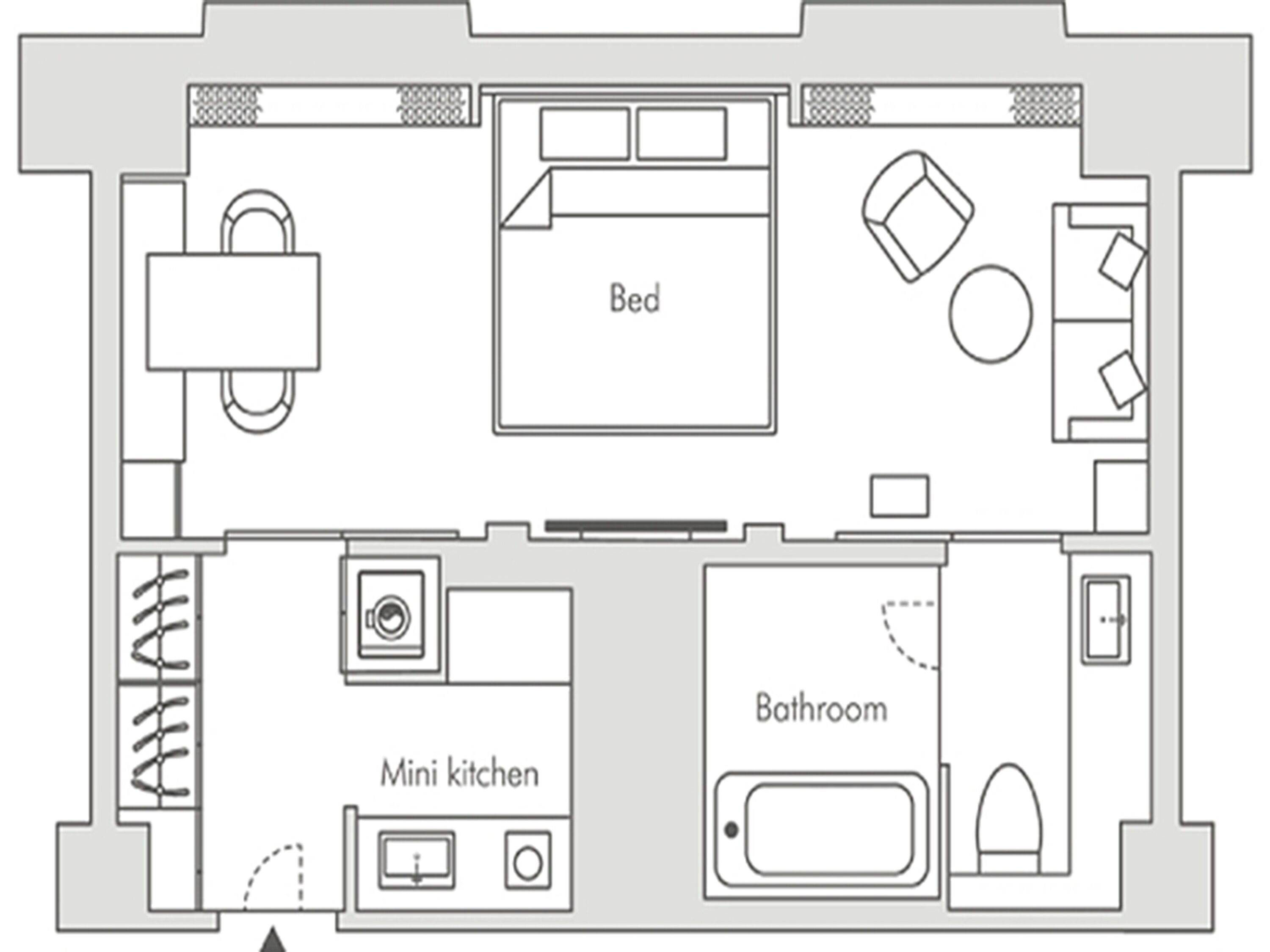 A floor plan of a hotel room with a bed, a mini kitchen, a bathroom, and a seating area.