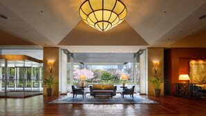 A lobby with a large chandelier, a sofa, two armchairs, and a potted plant. - Nagoya Kanko Hotel (Nagoya)