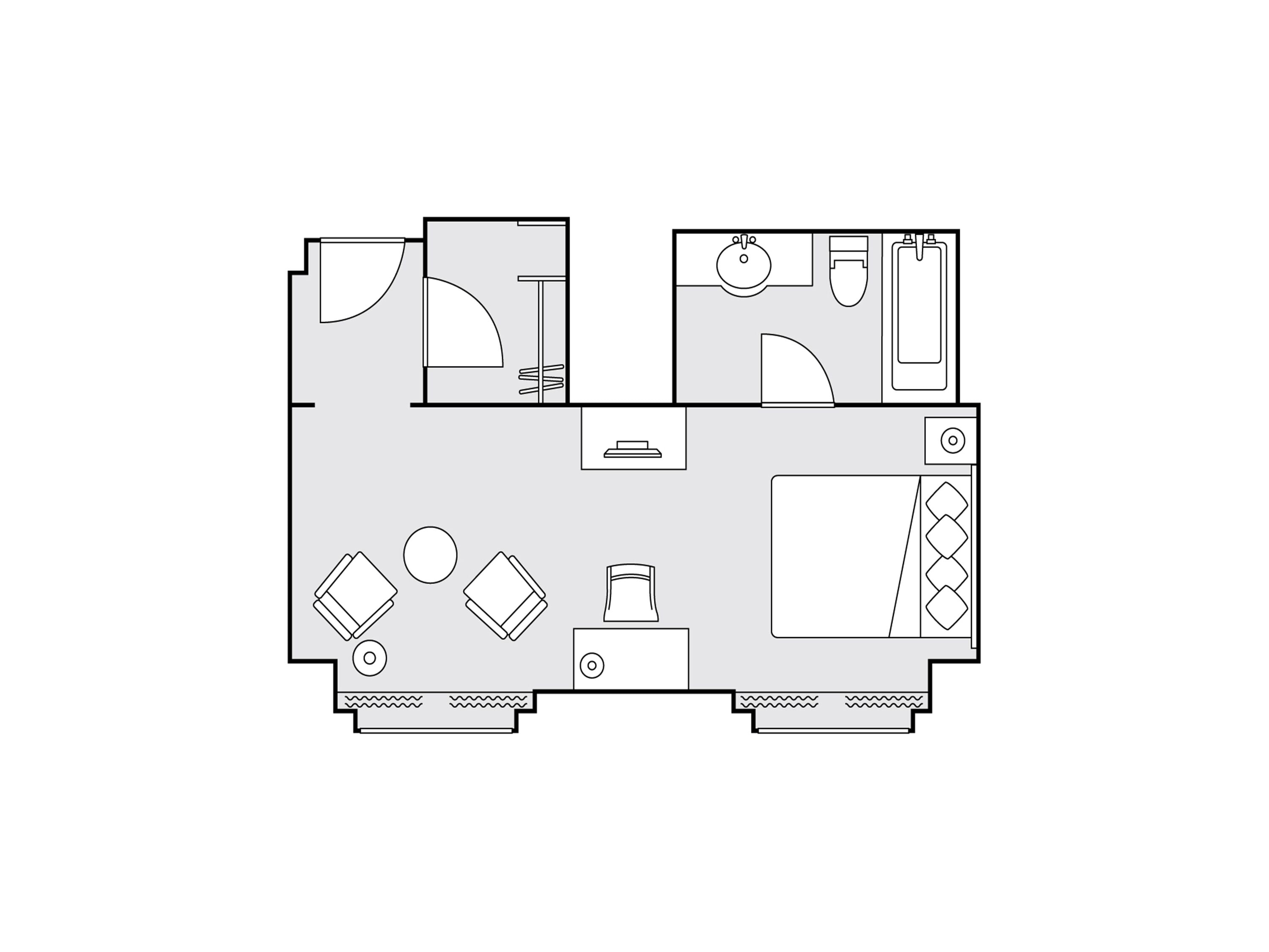 A floor plan of a hotel room with a bathroom, a kitchenette, a seating area with a table and chairs, and a large window.