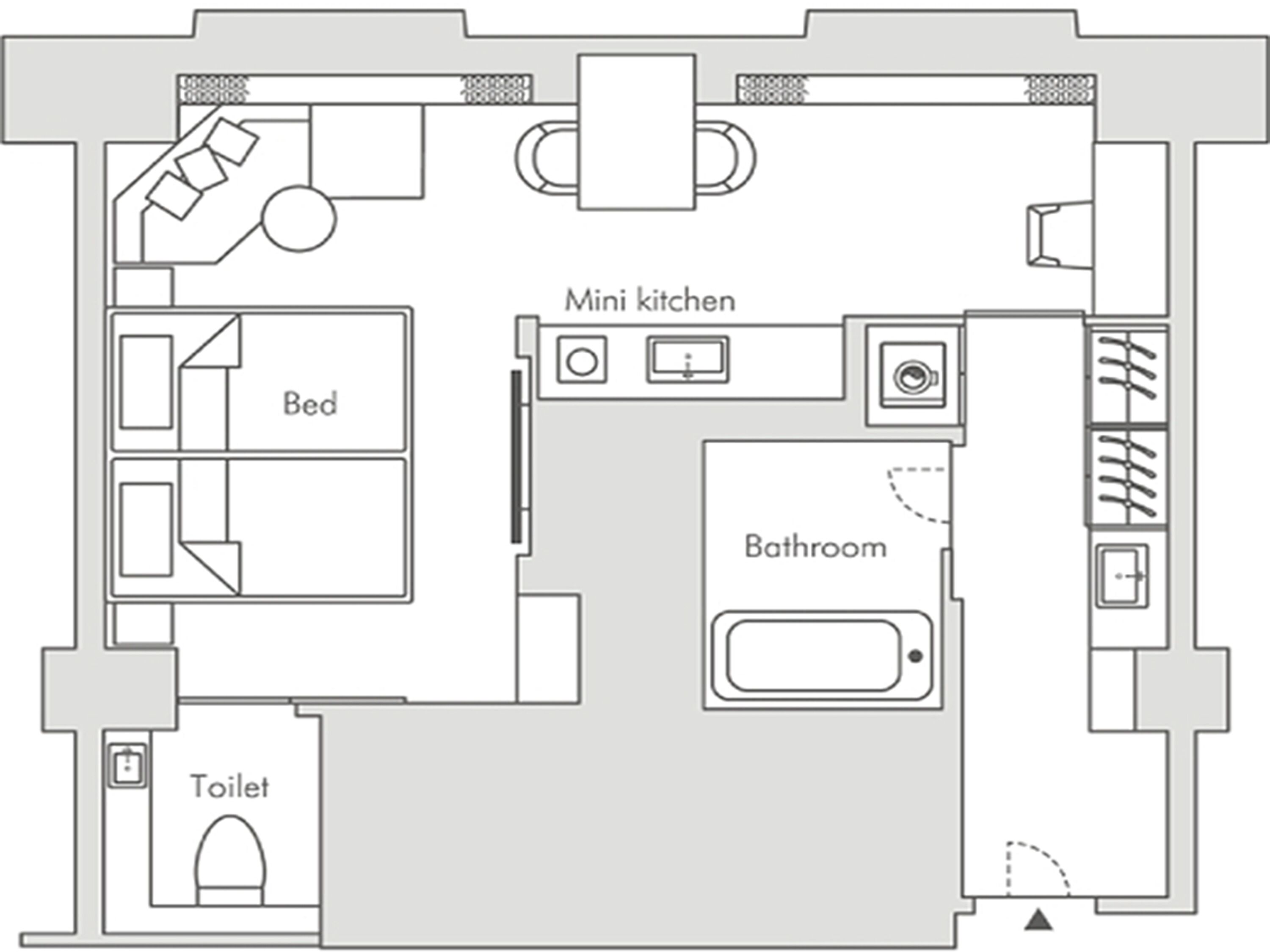 Plano de planta que muestra una cama, kitchenette, baño y retrete.