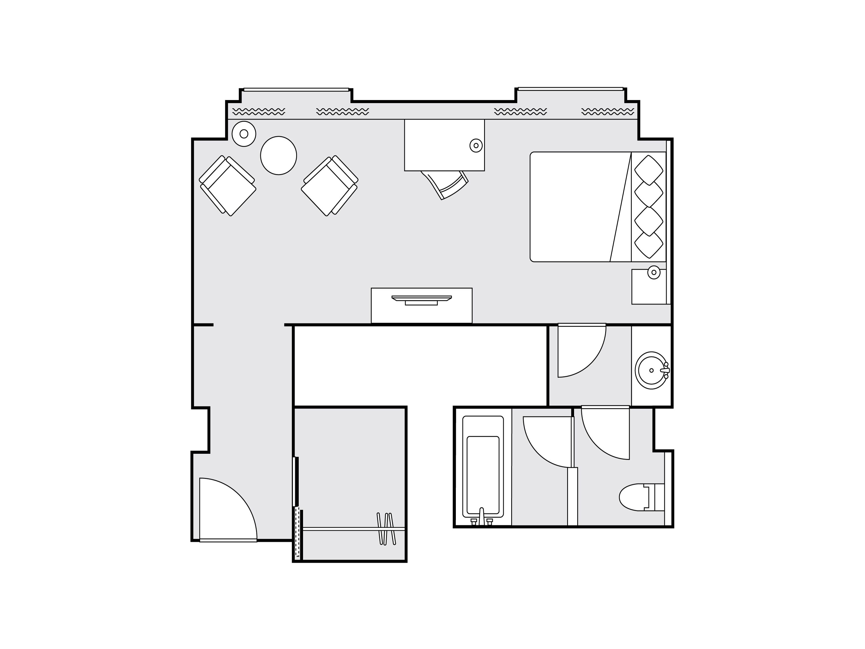 A floor plan of a hotel room with a bed, a desk, a chair, a small bathroom, and a seating area.