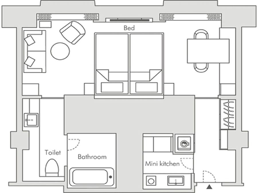 A floor plan with a bed, two bathrooms, a toilet, and a mini kitchen.