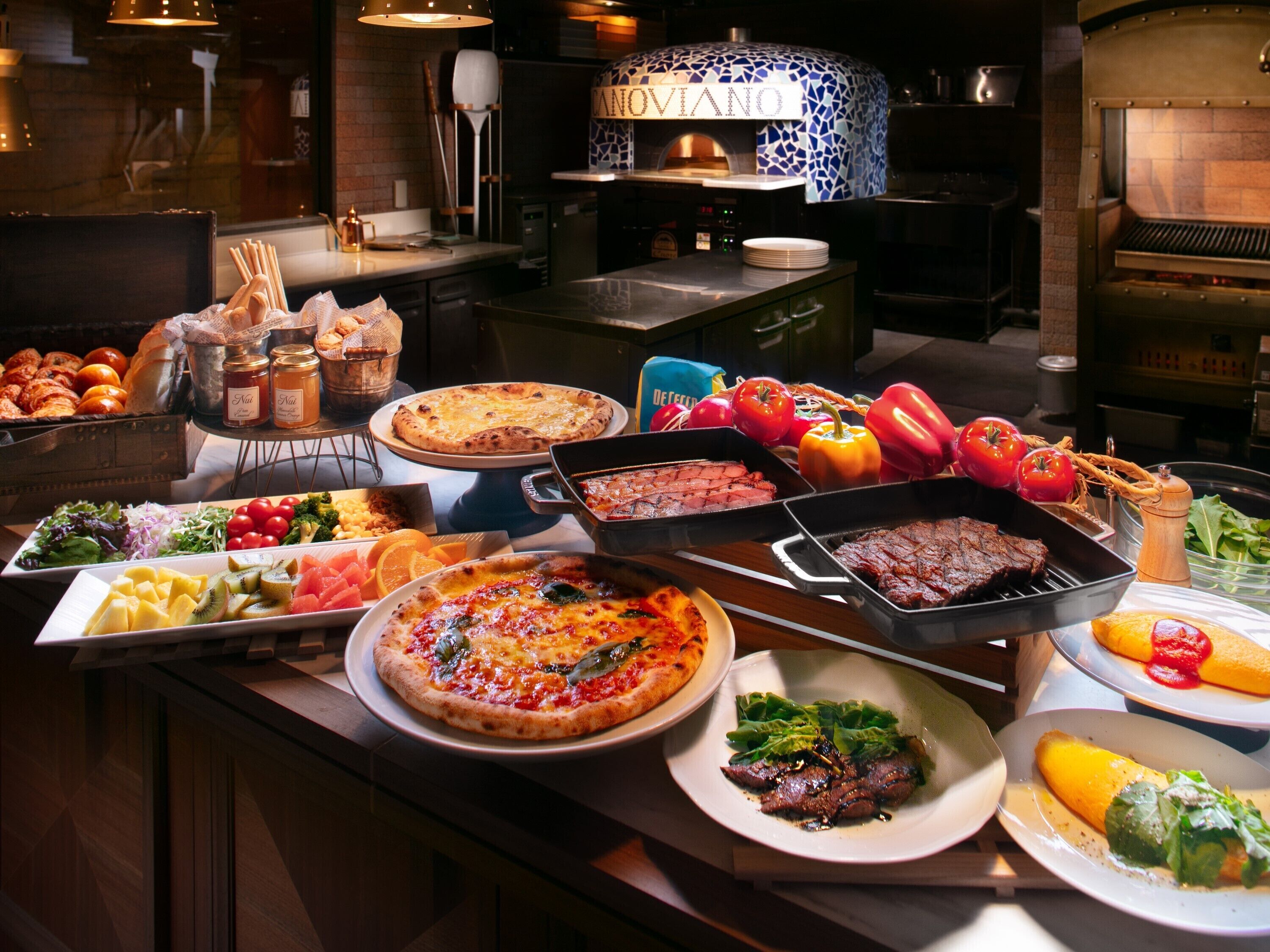 A buffet with various dishes including pizzas, salads, and meats.