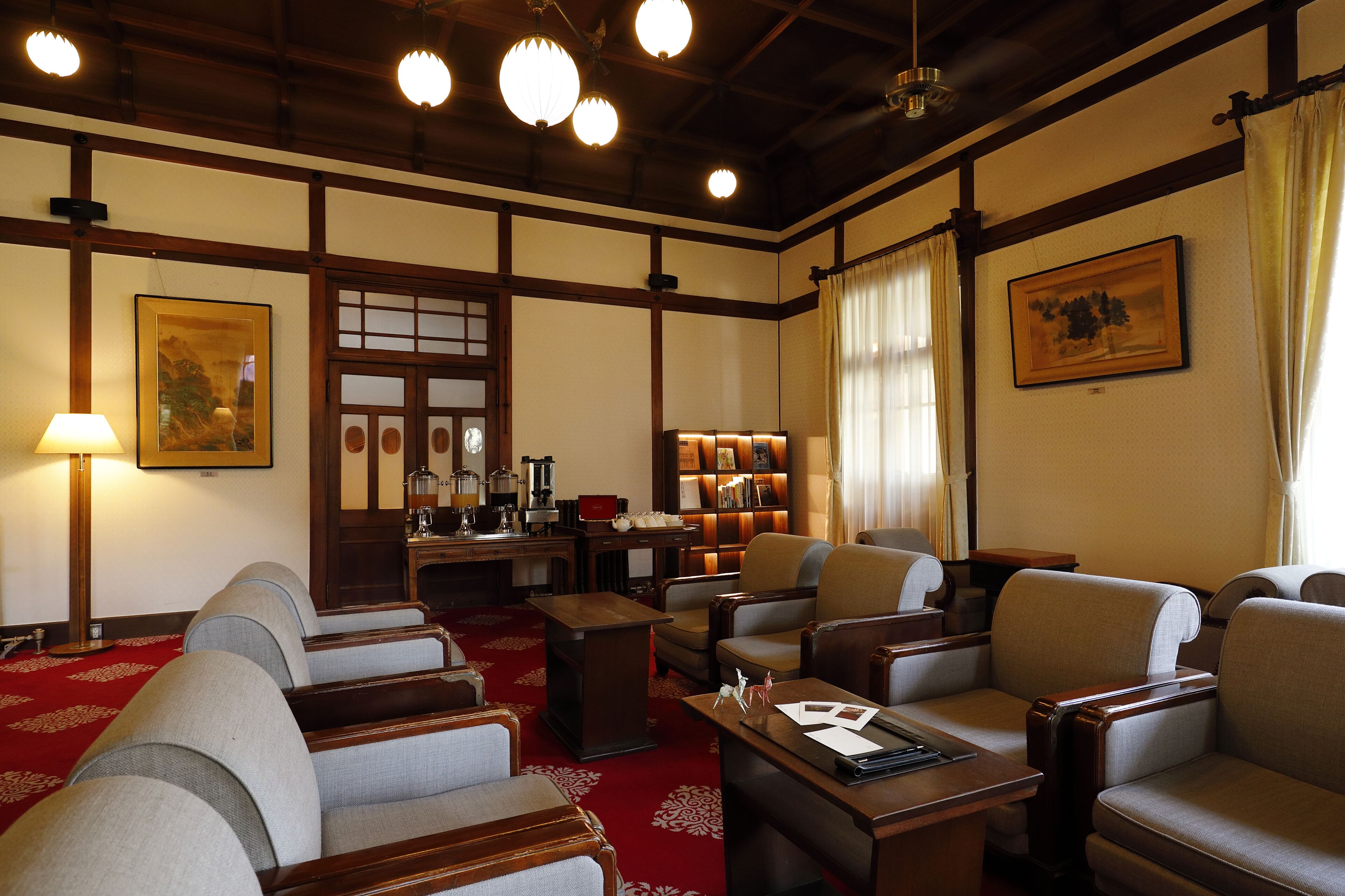 Une pièce de style japonais traditionnel, avec un sol recouvert de tatamis, de petites tables basses en bois et des coins salon.