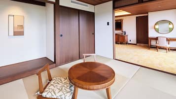 A traditional Japanese room with tatami flooring, a round wooden table, and a low wooden cabinet.