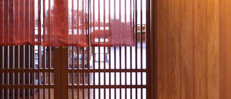 Una habitación tradicional japonesa con puertas correderas de madera, suelo de esteras de tatami y un cartel con caracteres japoneses.