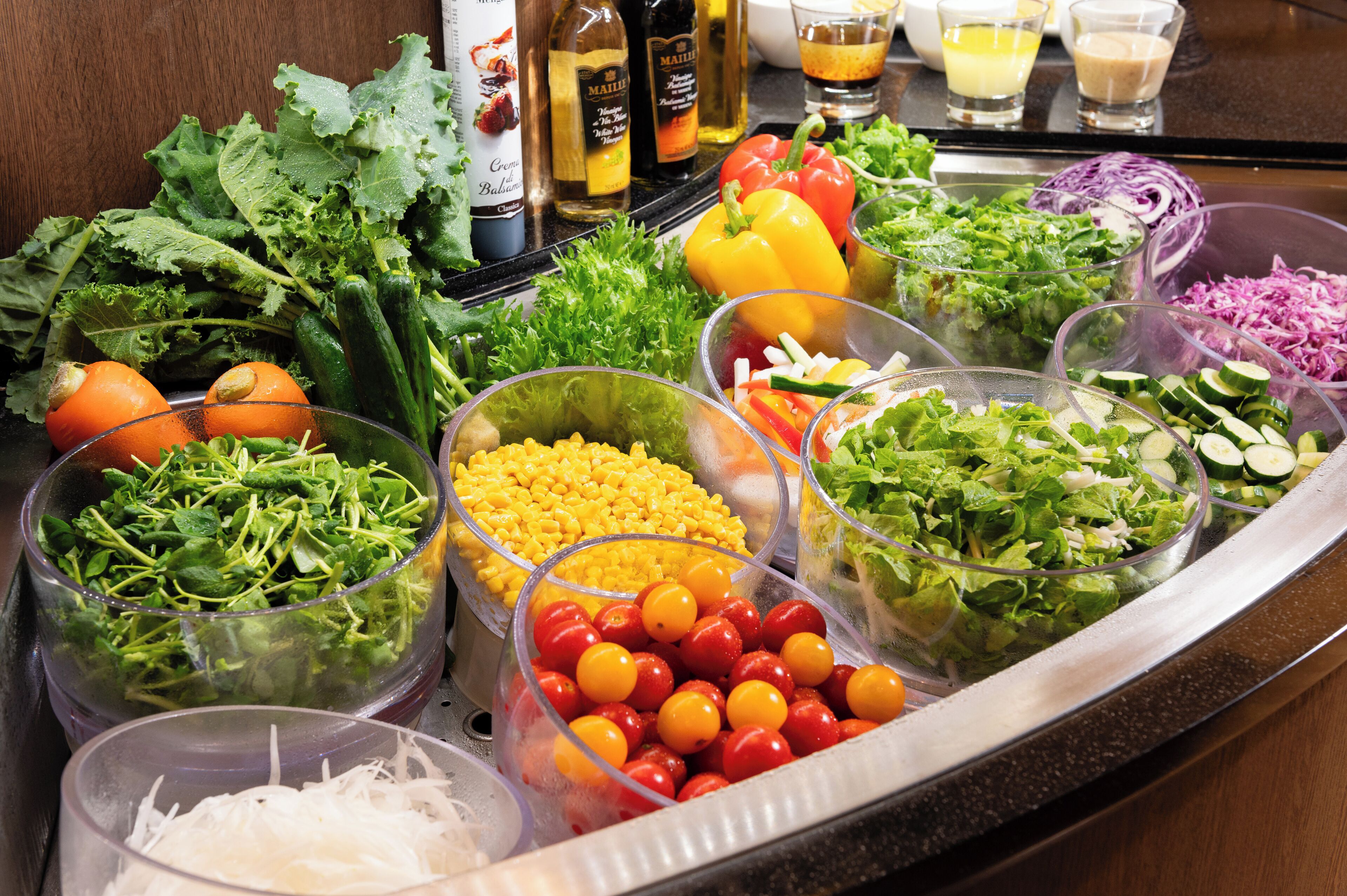 Un bufé con diversas opciones de verduras frescas y ensaladas.