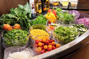 A buffet with various fresh vegetables and salad options.