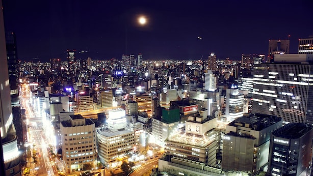 A nighttime cityscape with illuminated buildings and a crescent moon. - Hotel Granvia Osaka (Osaka)