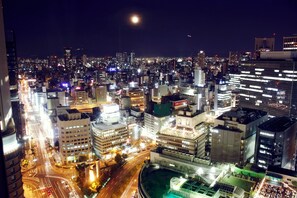 A nighttime cityscape with illuminated buildings and a crescent moon. - Hotel Granvia Osaka (Osaka)