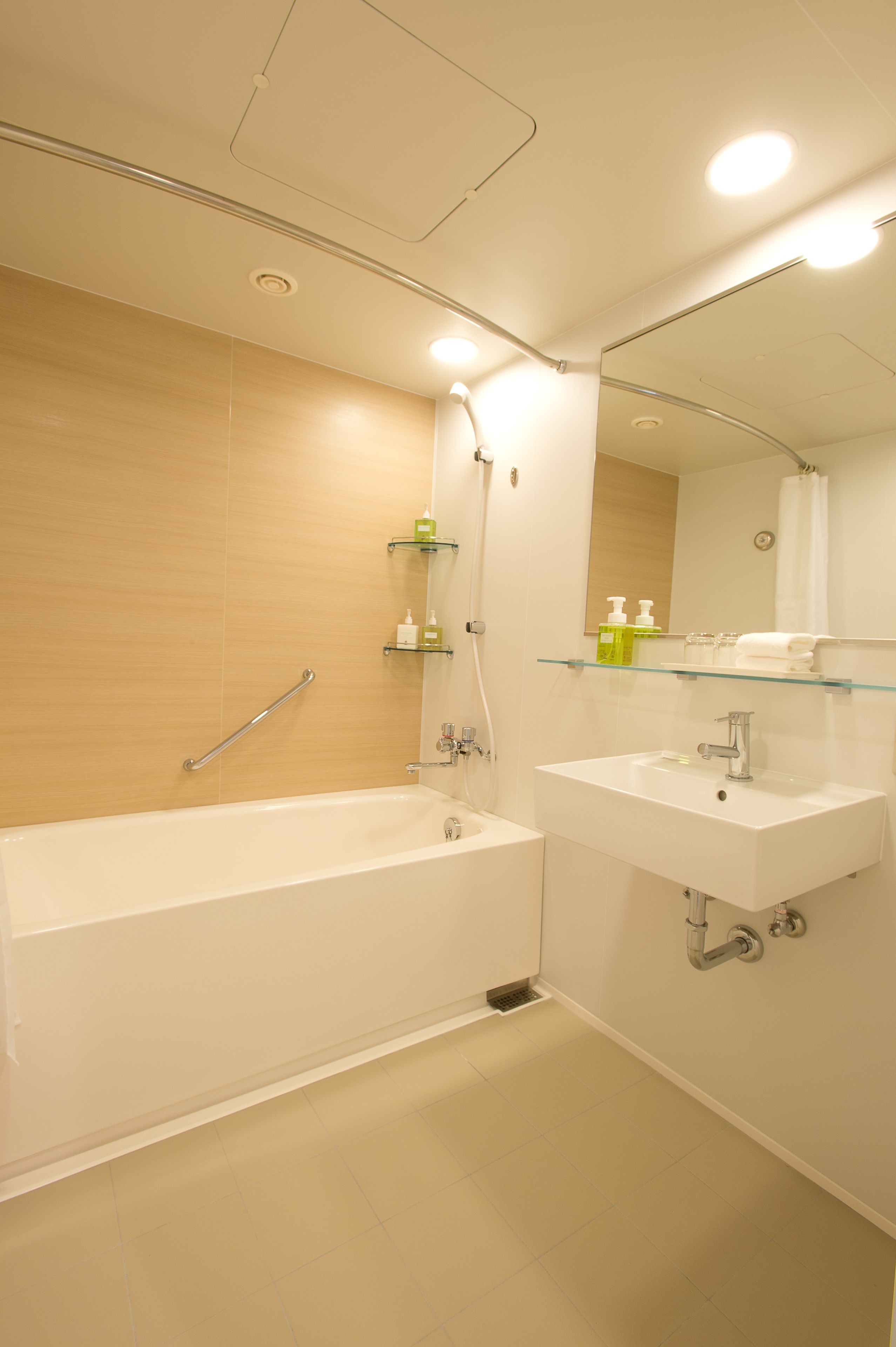 A modern bathroom with a bathtub, a sink, and a mirror.