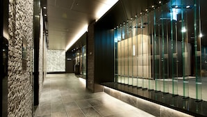 A modern hallway with a stone wall on one side and a glass partition on the other. - Hotel Granvia Osaka (Osaka)
