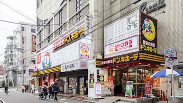 Una hilera de bares de karaoke japoneses con letreros y anuncios de neón.