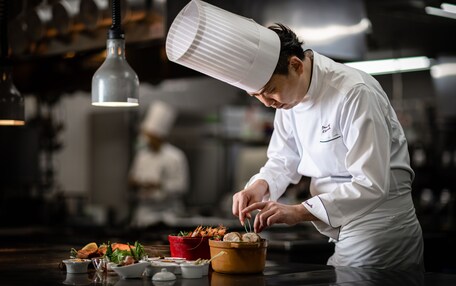 A chef in a professional kitchen preparing food.