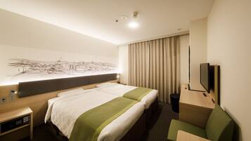 A hotel room with two beds, a desk, a chair, a TV, and a large window with curtains.