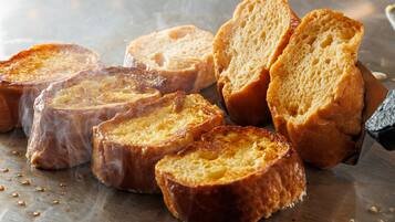 Slices of toasted bread on a metal surface with steam rising from them.