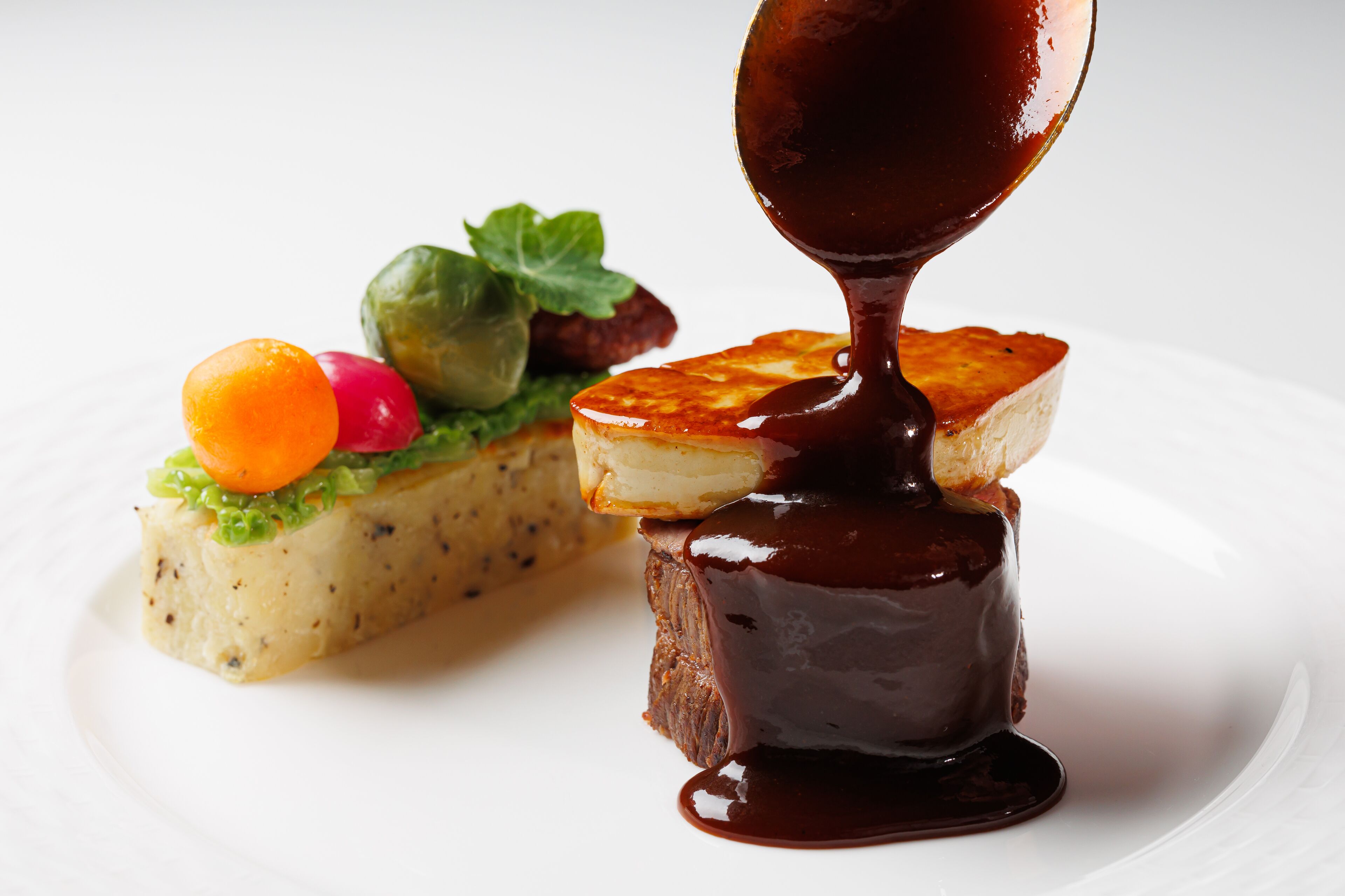 A dessert with chocolate sauce being poured over it.