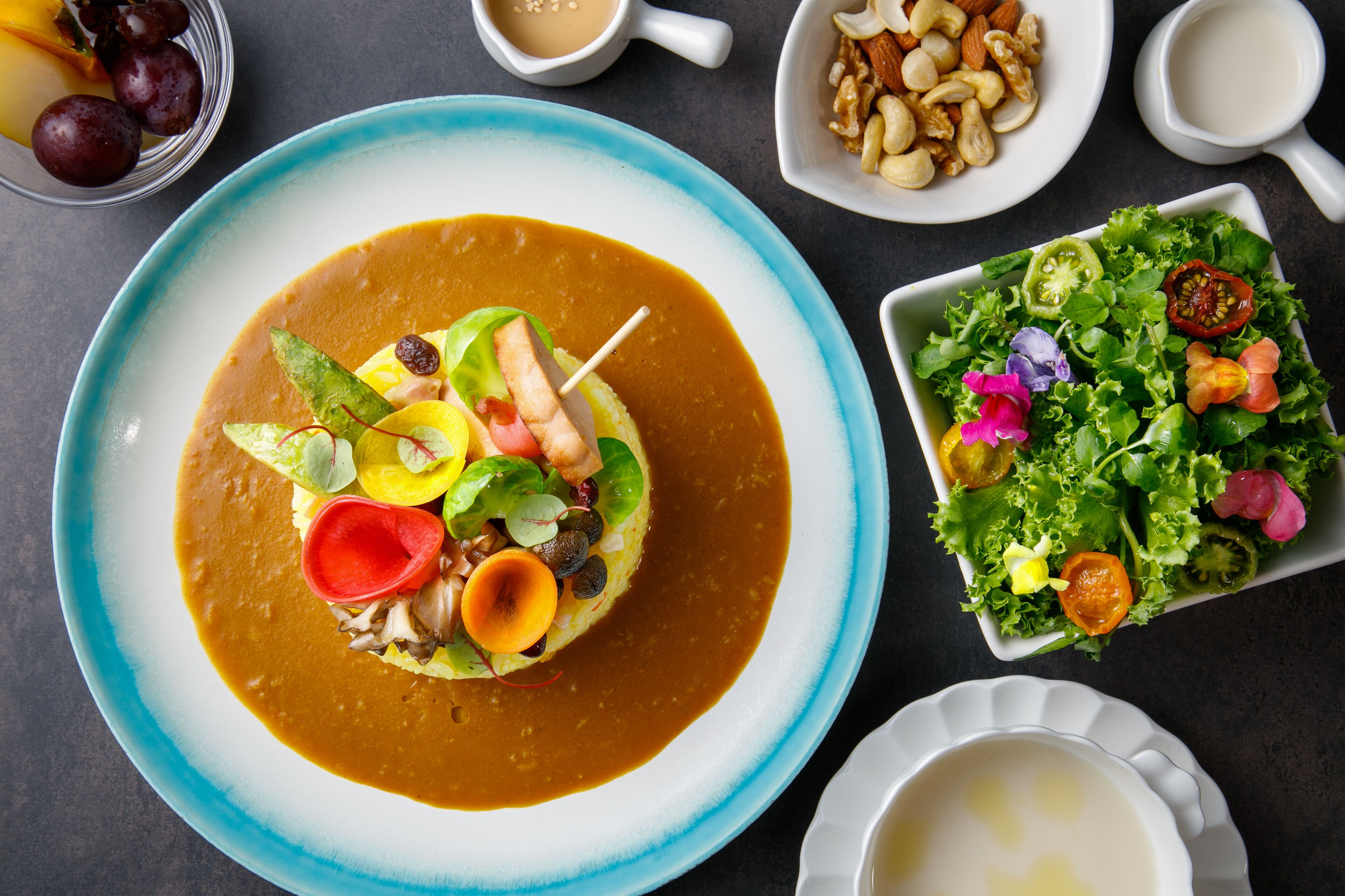 A plate of food with a variety of vegetables and a sauce.