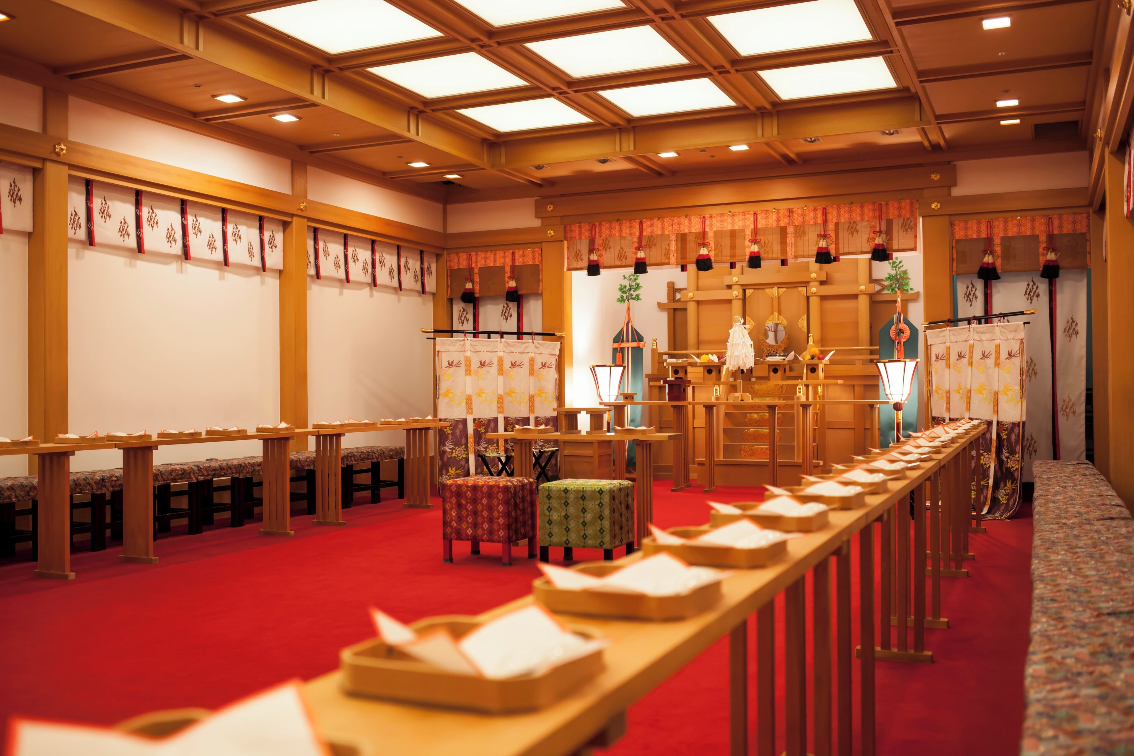 A traditional Japanese-style room with tatami mats, wooden furniture, and a central altar.