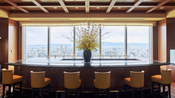 A bar area with a city view, a round table, and six chairs. - Imperial Hotel, Osaka (Osaka)