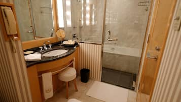 A bathroom with a sink, mirror, and shower.