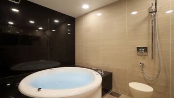 A modern bathroom with a freestanding bathtub, a separate shower area, and a toilet.