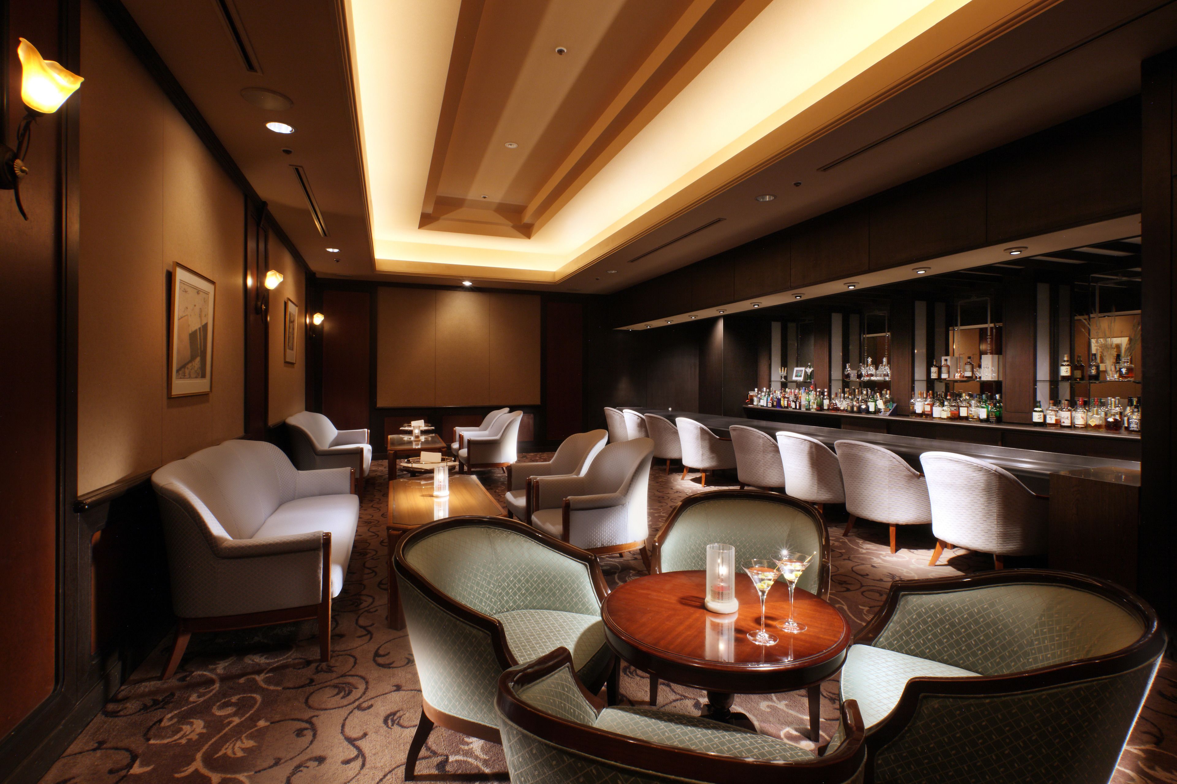 A hotel bar area with seating and a bar counter.