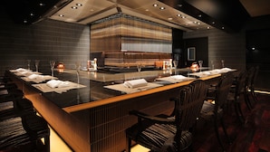 A modern bar area with a long counter, multiple seating arrangements, and a central decorative structure. - Hotel Metropolitan Sendai (Sendai)