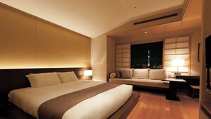 A modern hotel room with a large bed, a sofa, a desk, and a nightstand. - Hotel East 21 Tokyo (Tokyo)