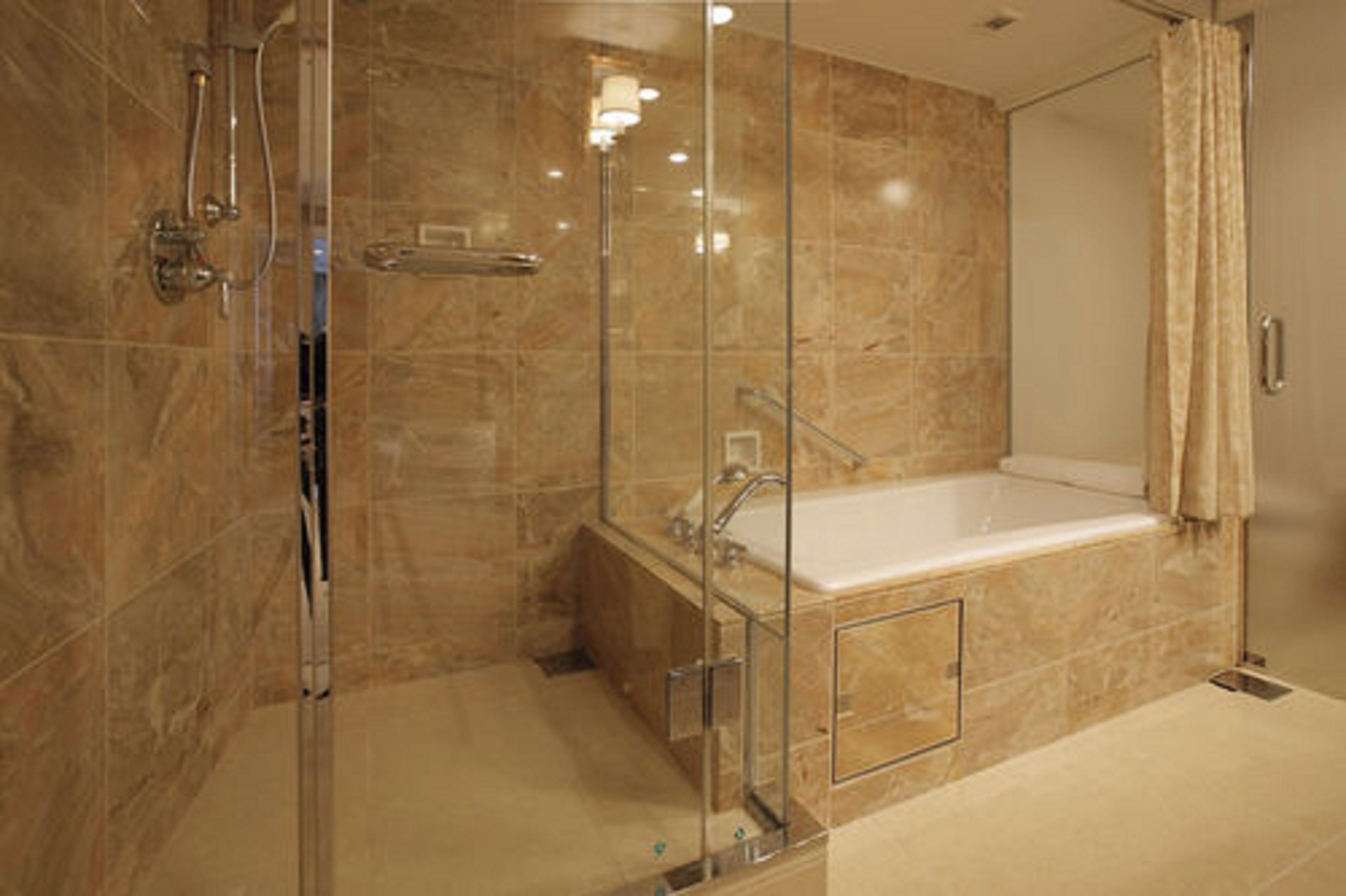 A modern bathroom with a glass-enclosed shower, a standalone bathtub, and a vanity with a mirror.