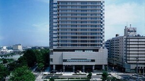 Un hôtel moderne, avec une enseigne bien visible sur le toit, de nombreux étages et un toit plat.