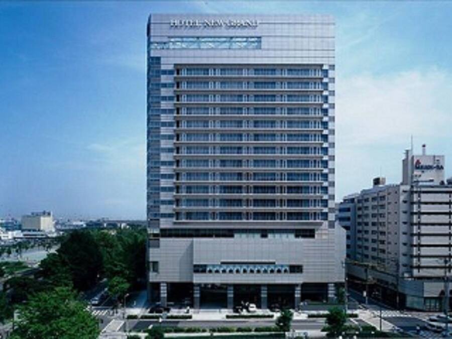 A modern hotel building with a prominent sign at the top, multiple floors, and a flat roof.