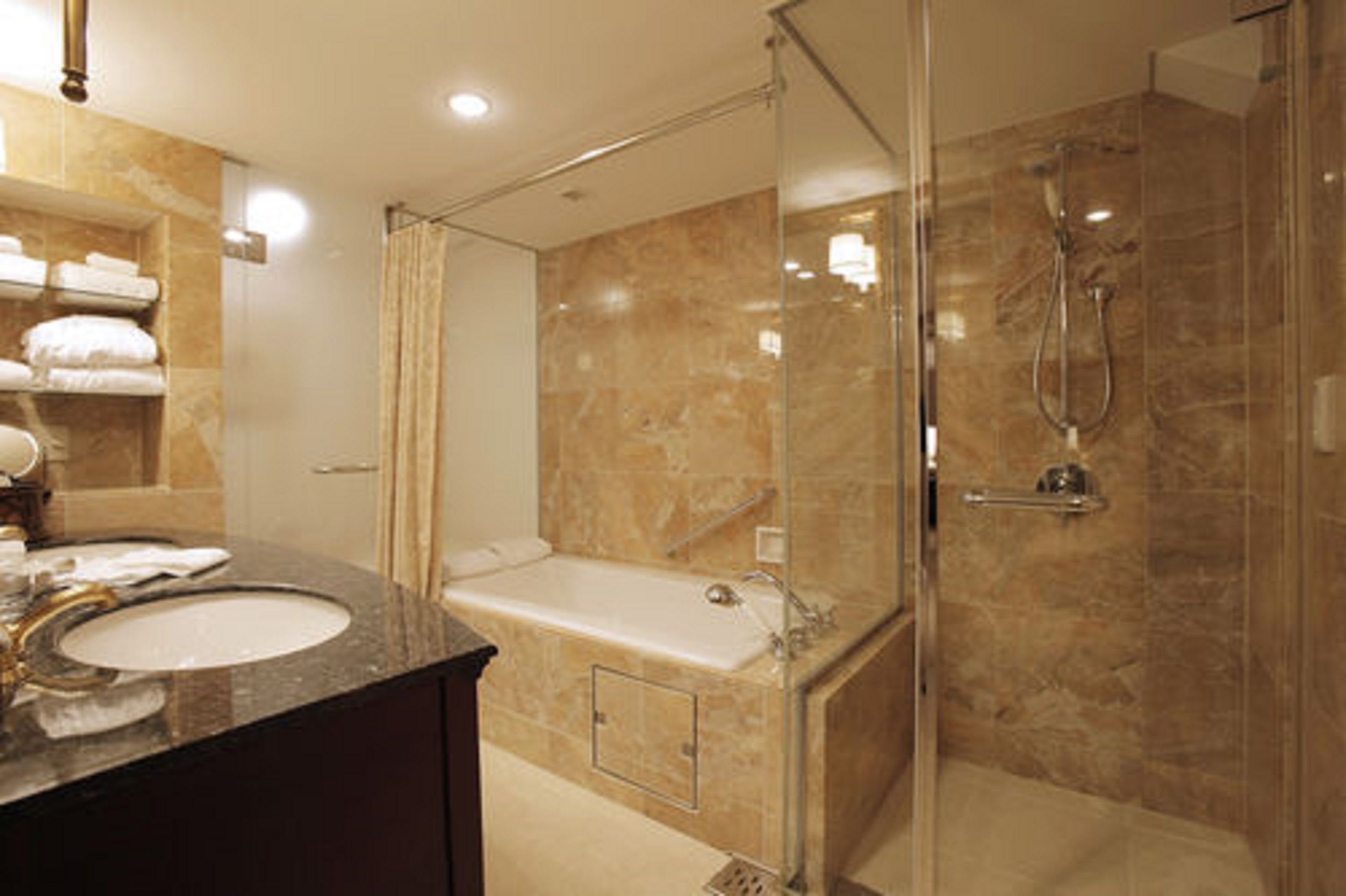 Ein modernes Badezimmer mit einer einachthässigen Duschkabine, einer Badewanne und einem Waschtisch.