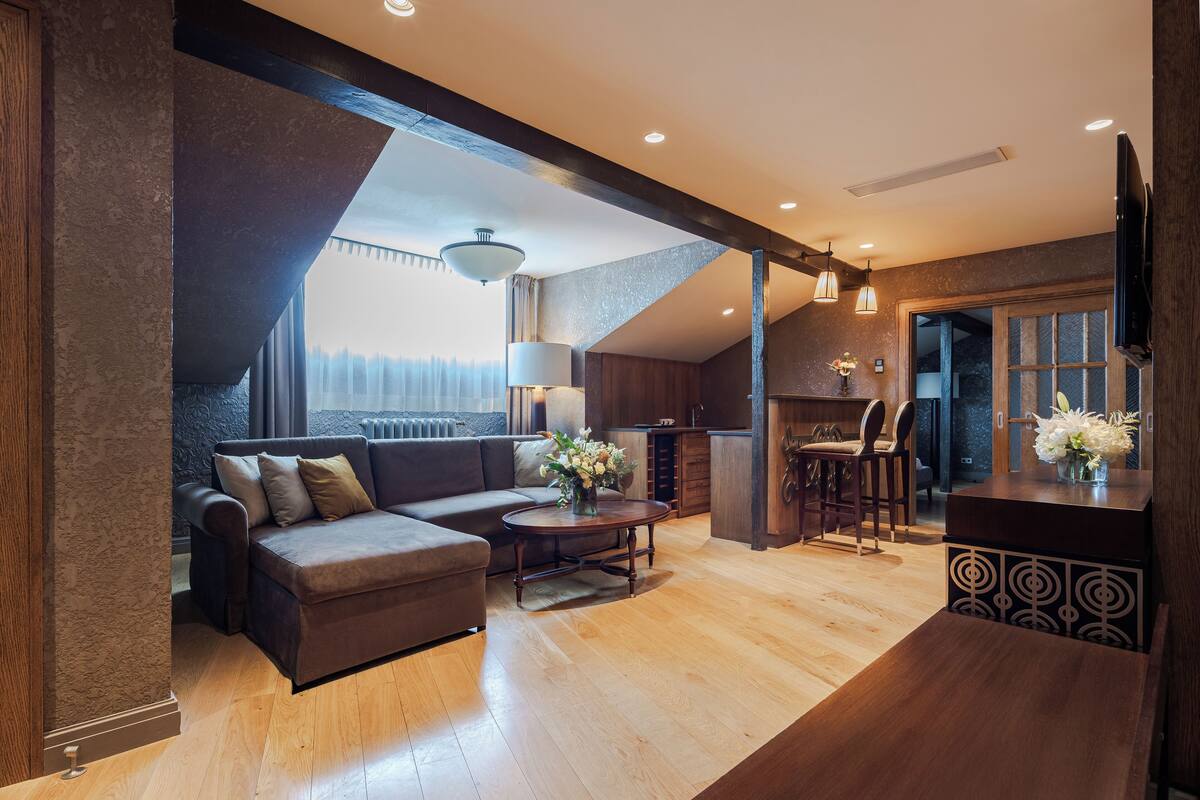 A modern living room with a sofa, coffee table, and a dining area with chairs.