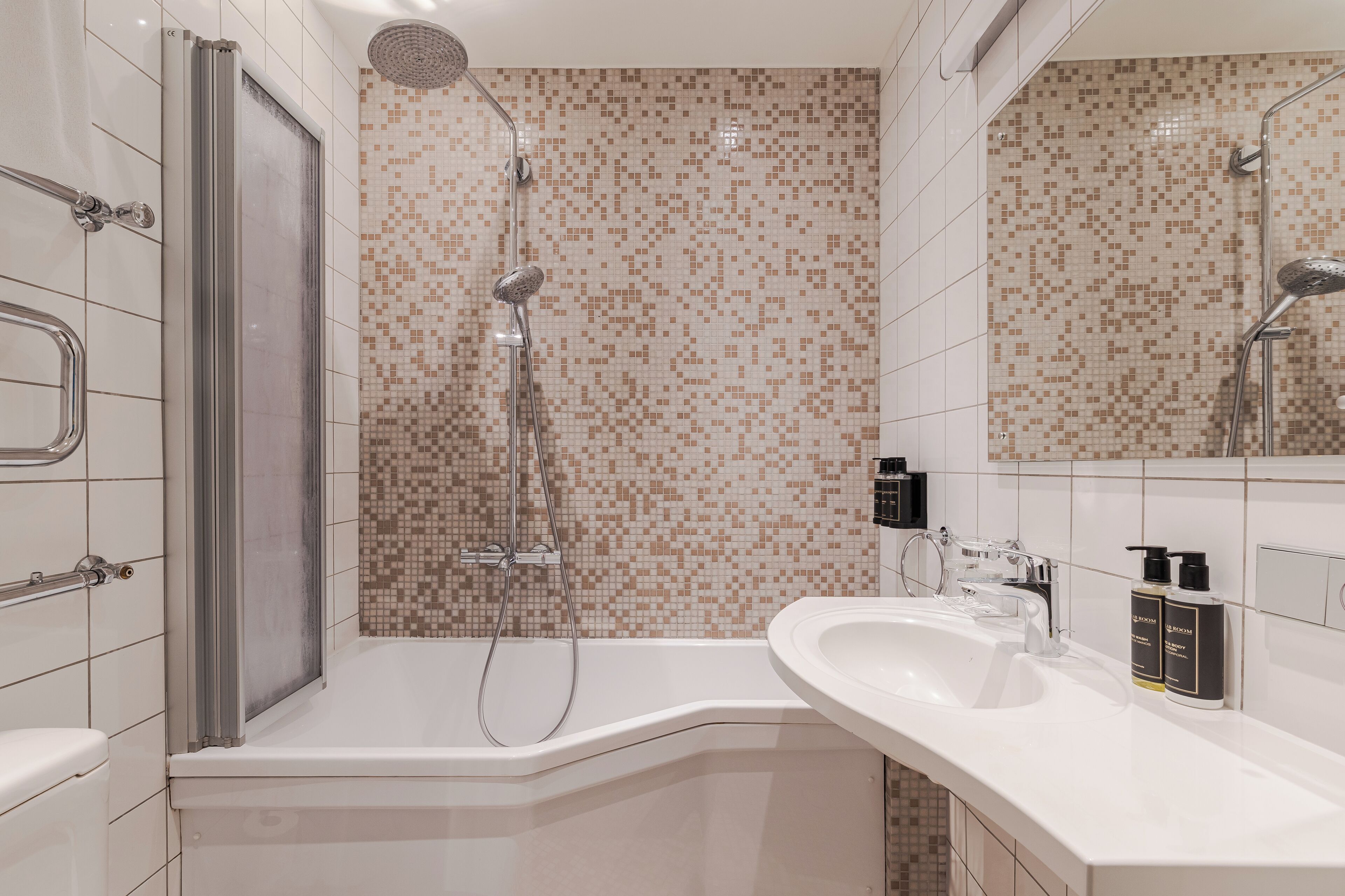 Une salle de bain moderne équipée d’une douche, de toilettes et d’un lavabo.