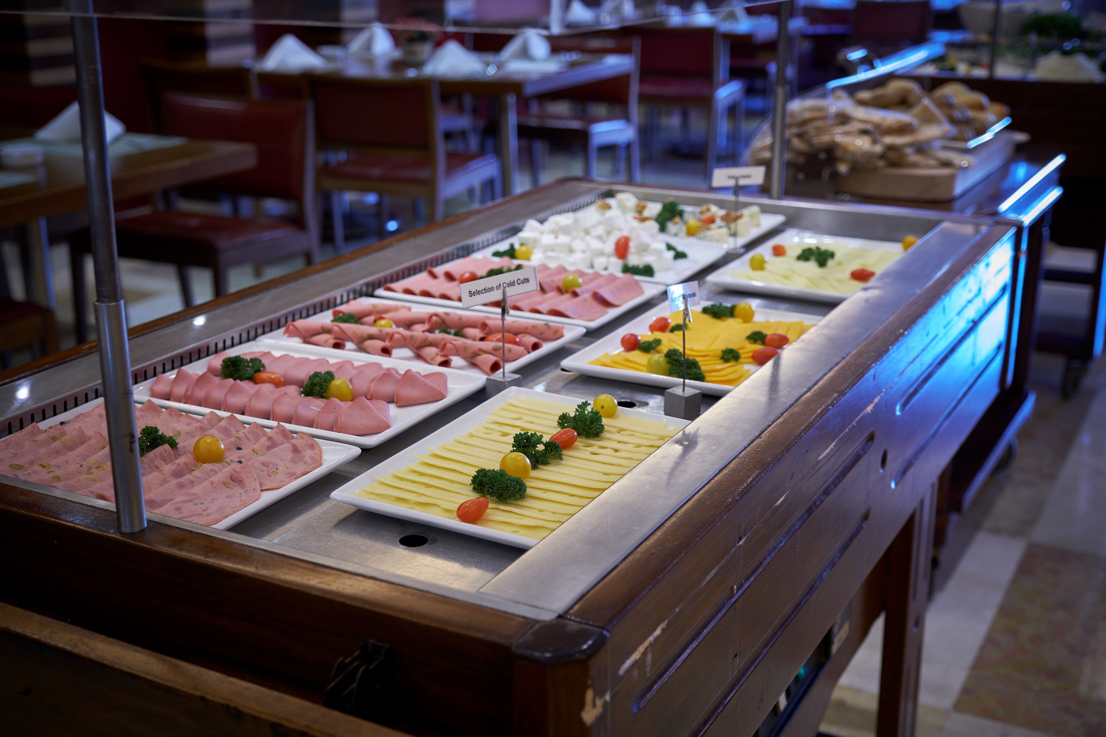 A buffet with various cold cuts and cheeses.