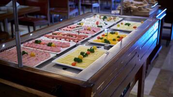 A buffet with various cold cuts and cheeses.