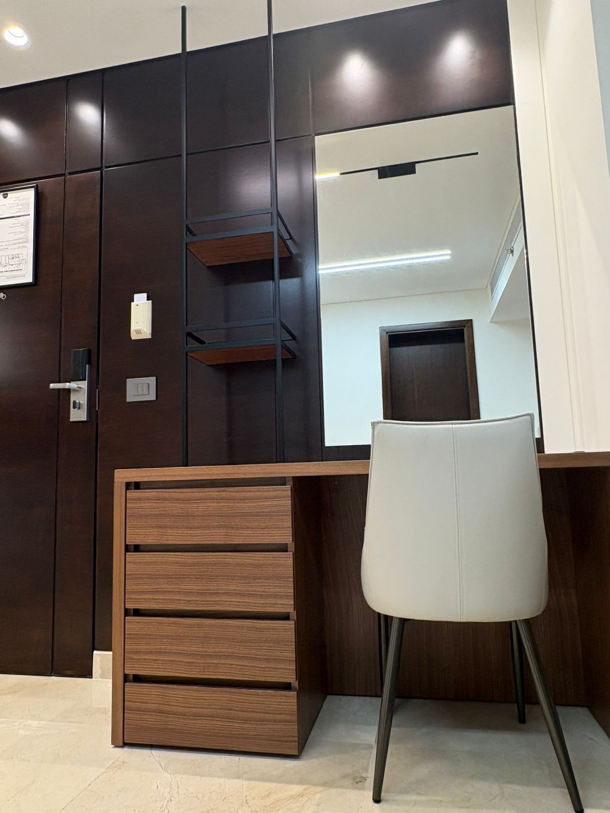Un espacio de oficina moderno con un escritorio, una silla y un espejo grande.