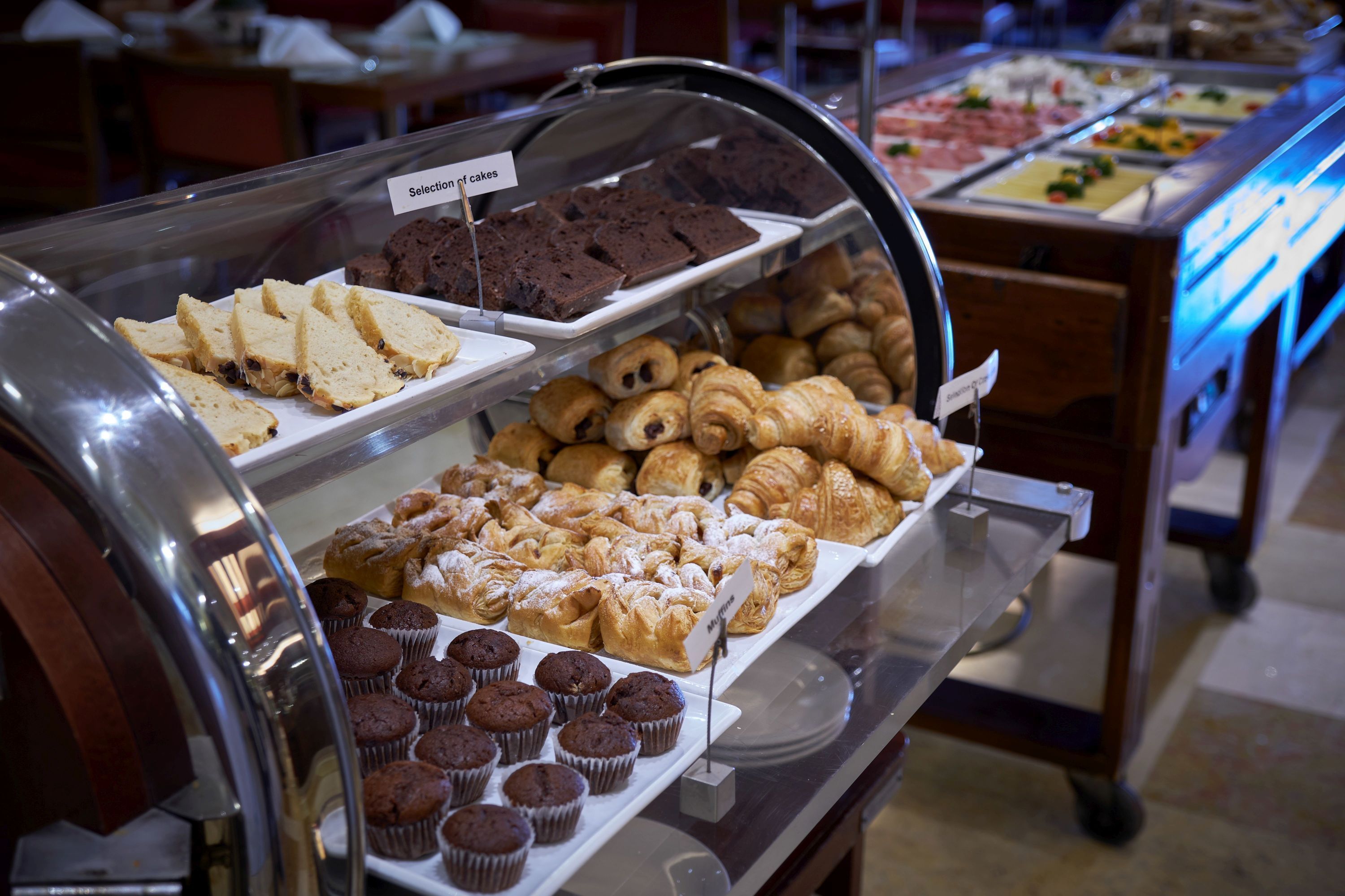 A buffet with various baked goods including cakes, muffins, and pastries.