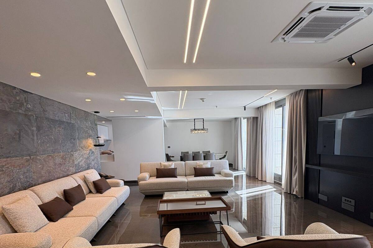 Un salon moderne comprenant un canapé, des fauteuils, une table basse et une cheminée.