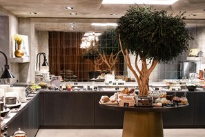 Una cocina moderna con una isla central, una gran escultura de árbol y diversos alimentos a la vista.