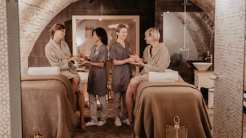 Relax in a serene spa setting with a rustic archway leading to a treatment room featuring comfortable seating and soothing ambiance.