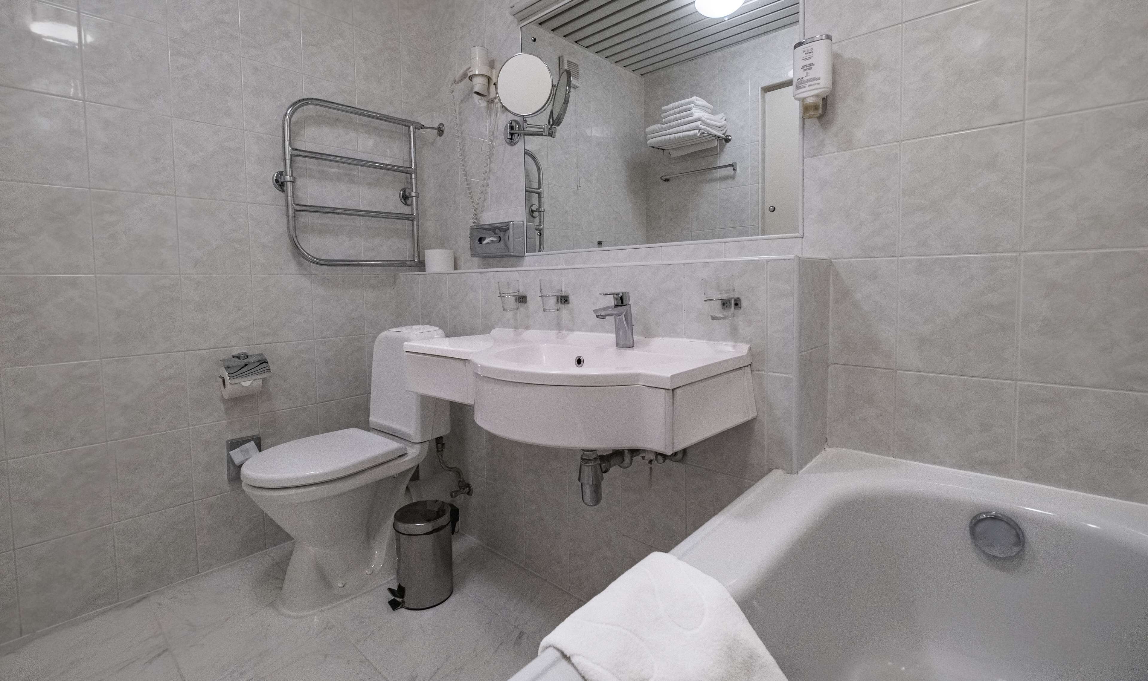 A modern bathroom with a toilet, sink, and bathtub.
