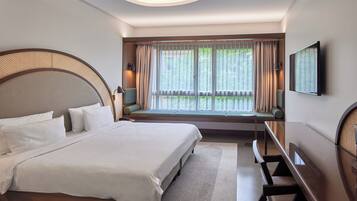 Una habitación de hotel moderna con una cama grande, un banco junto a la ventana y un televisor de pantalla plana en la pared.