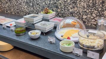 A buffet counter with various food items and labels.