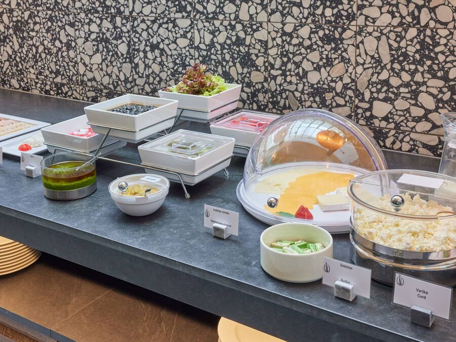 A buffet counter with various food items and labels.