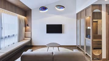 Una sala de estar moderna con un sofá, una mesita y un televisor montado en la pared.